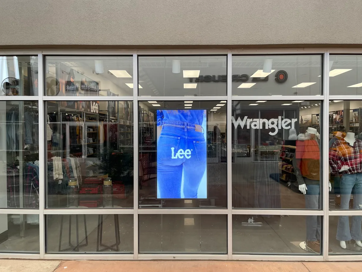 Lee and Wrangler outlet storefront with a portrait digital window display