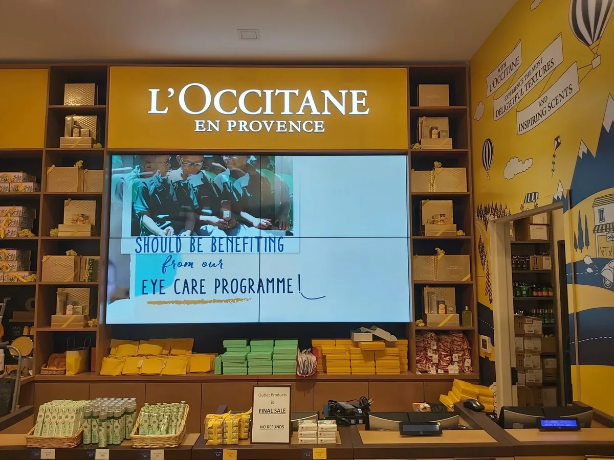 Retail video wall: a 3x3 Samsung wall above shelving in an L'Occitane boutique